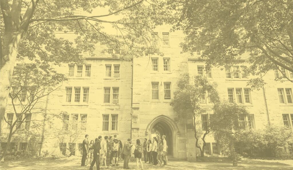A building in front of a yard where a group of students have gathered